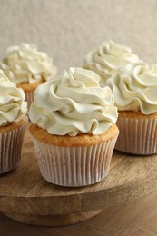 Photo of Tasty vanilla cupcakes with cream on table, closeup