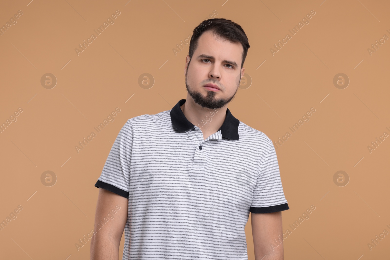 Photo of Portrait of sad man on beige background