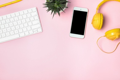 Photo of Flat lay composition with smartphone, computer keyboard and headphones on color background. Space for text