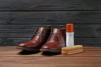 Photo of Leather footwear and shoe shine kit on wooden surface