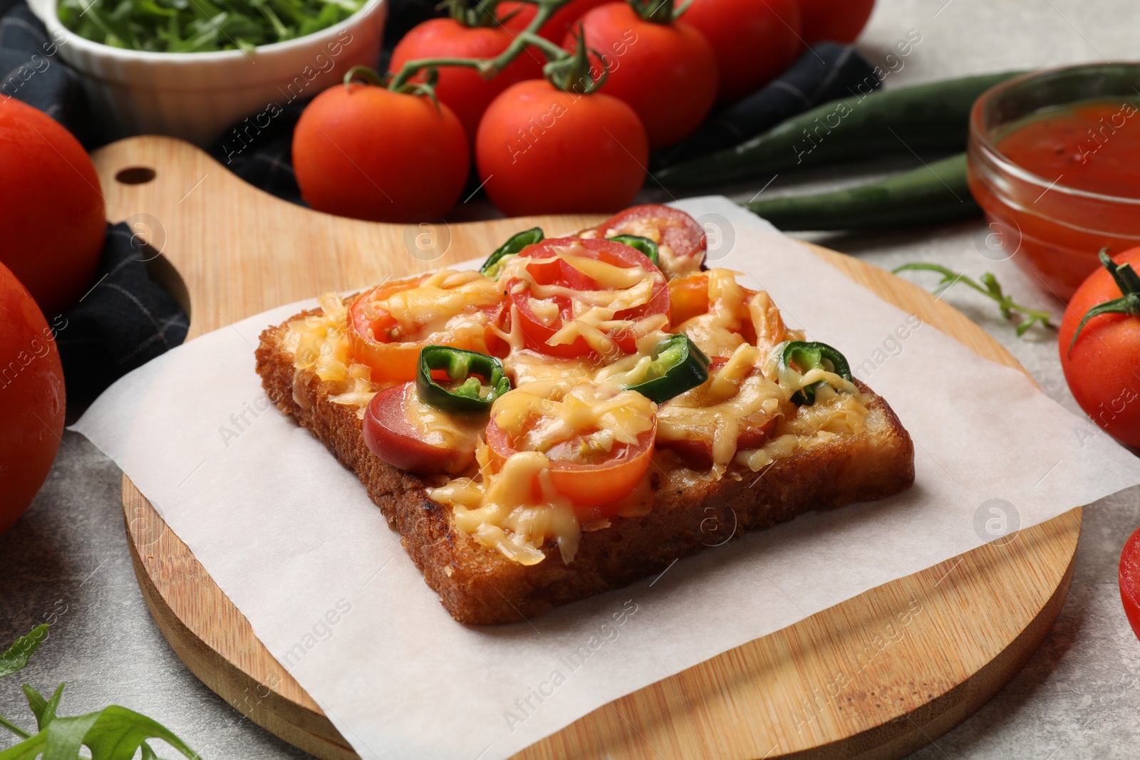 Photo of Tasty pizza toast, tomatoes and sauce on grey table, closeup