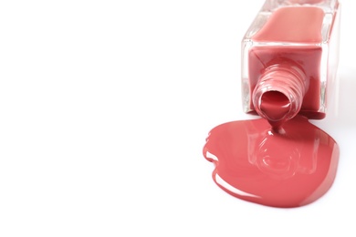 Spilled color nail polish with bottle on white background