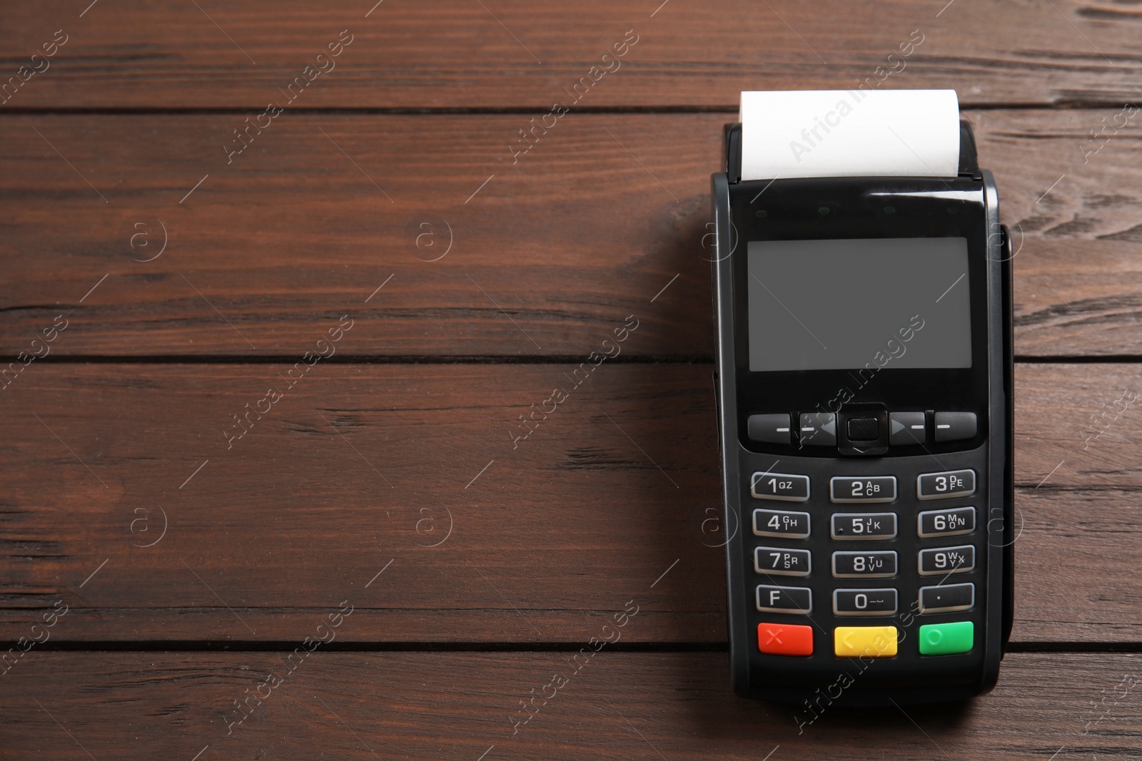 Photo of Modern payment terminal on wooden background, top view. Space for text