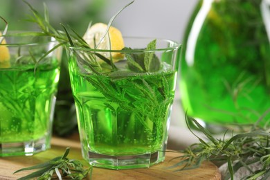 Photo of Refreshing tarragon drink with lemon slices on table, closeup