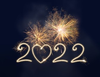 Image of Happy New Year greeting card design. 2022 silhouettes made of fireworks 