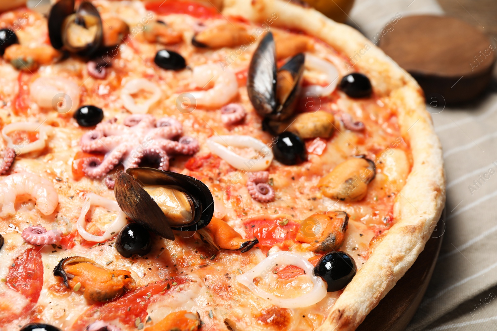 Photo of Tasty fresh pizza with seafood on table, closeup