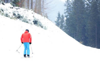 Skier on slope at resort, space for text. Winter vacation