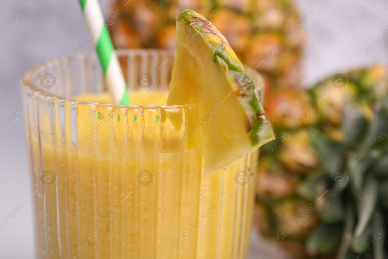 Photo of Tasty pineapple smoothie and cut fruit, closeup