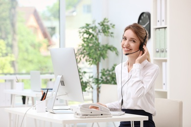 Female receptionist with headset at desk in office