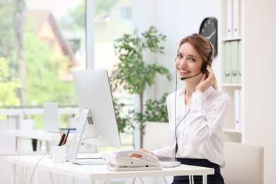 Photo of Female receptionist with headset at desk in office