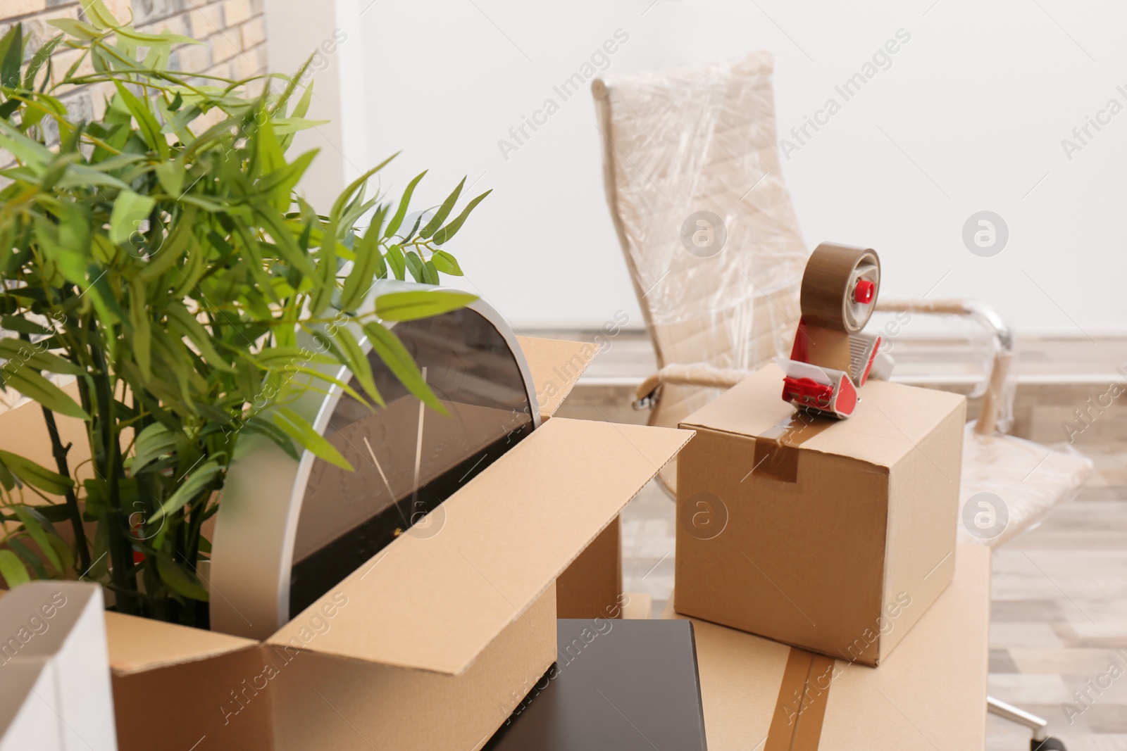 Photo of Moving box with office stuff on table indoors, closeup