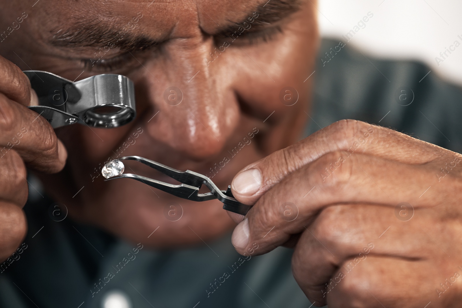 Photo of Professional jeweler evaluating beautiful gemstone, closeup view