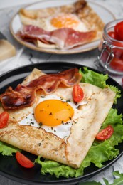 Photo of Delicious crepe with egg on table, closeup. Breton galette