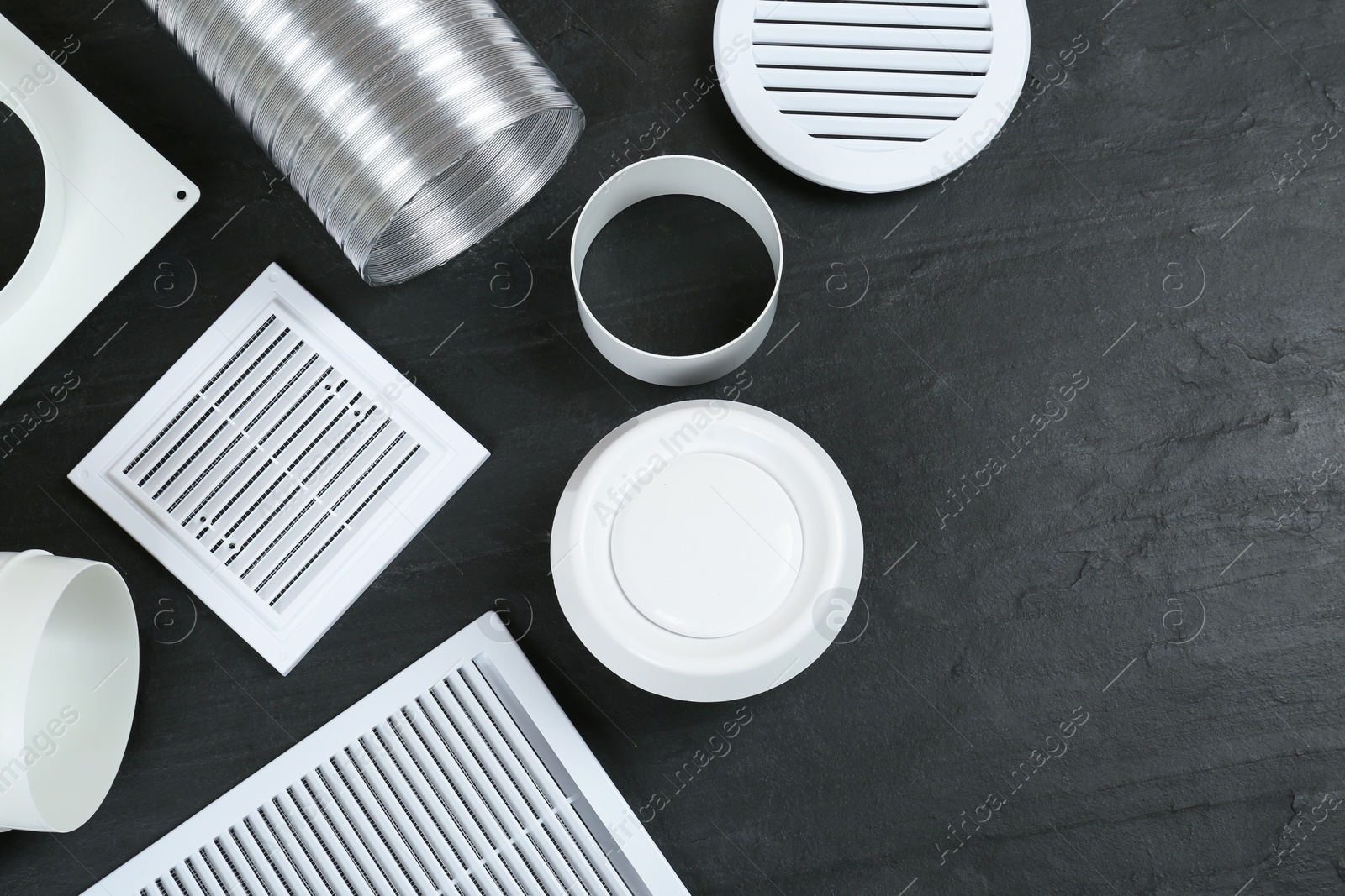 Photo of Parts of home ventilation system on black slate surface, flat lay. Space for text