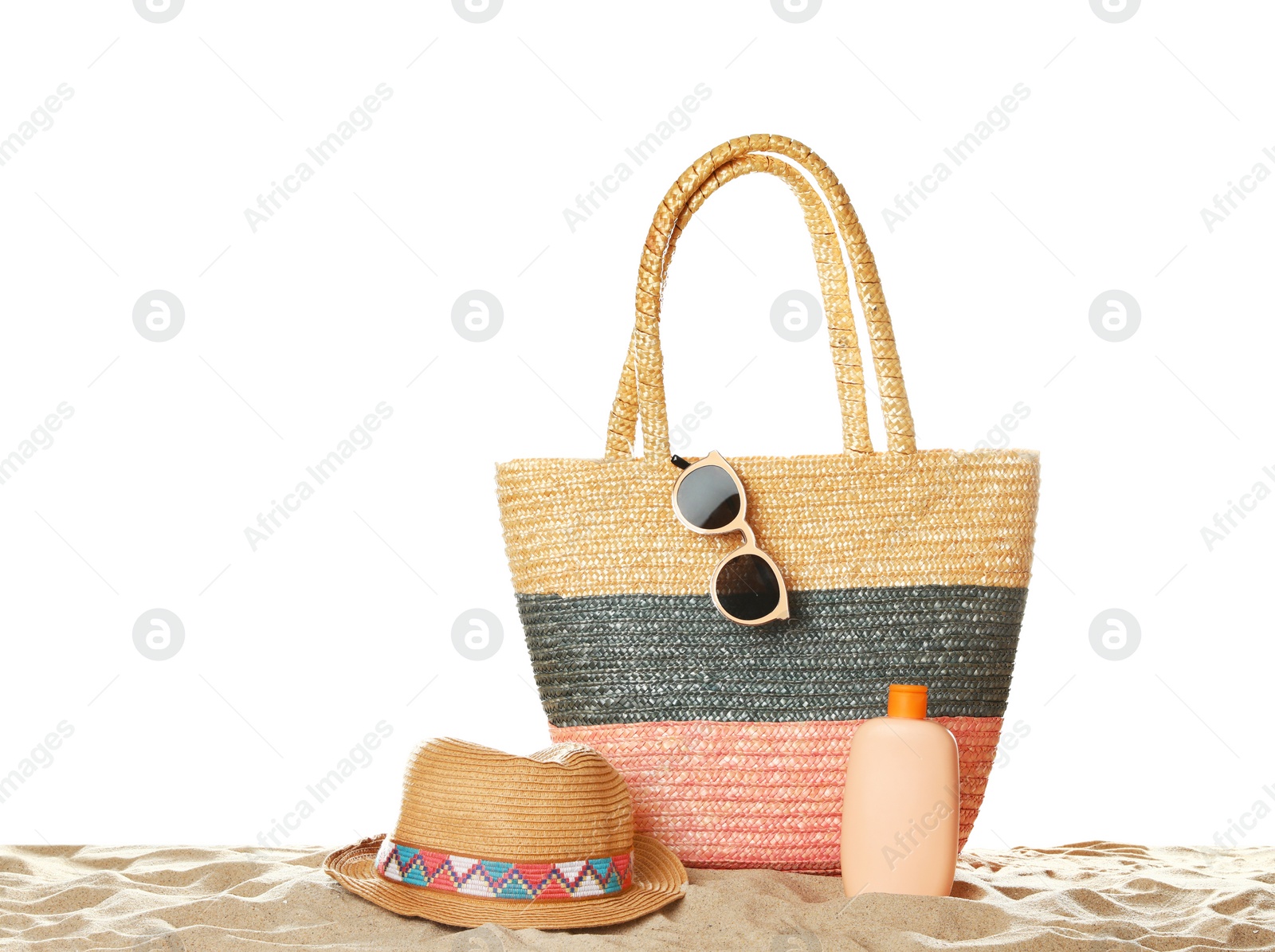 Photo of Wicker bag and beach accessories on sand against white background, space for text