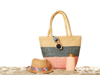 Photo of Wicker bag and beach accessories on sand against white background, space for text