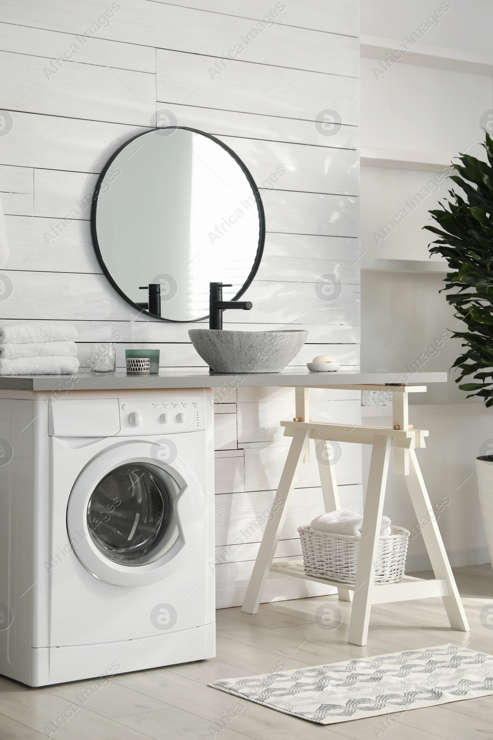 Photo of Stylish bathroom interior with modern washing machine