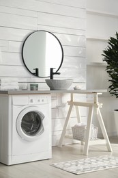 Stylish bathroom interior with modern washing machine