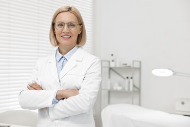 Portrait of happy dermatologist in modern clinic, space for text