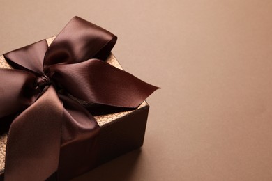 Photo of Beautiful gift box on brown background, space for text