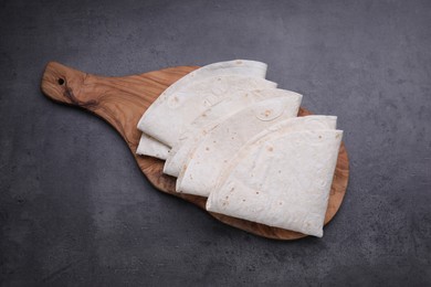Delicious folded Armenian lavash on dark table, top view