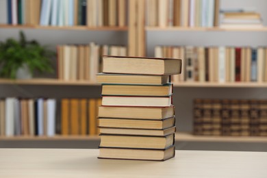 Photo of Stack of books on wooden table in library