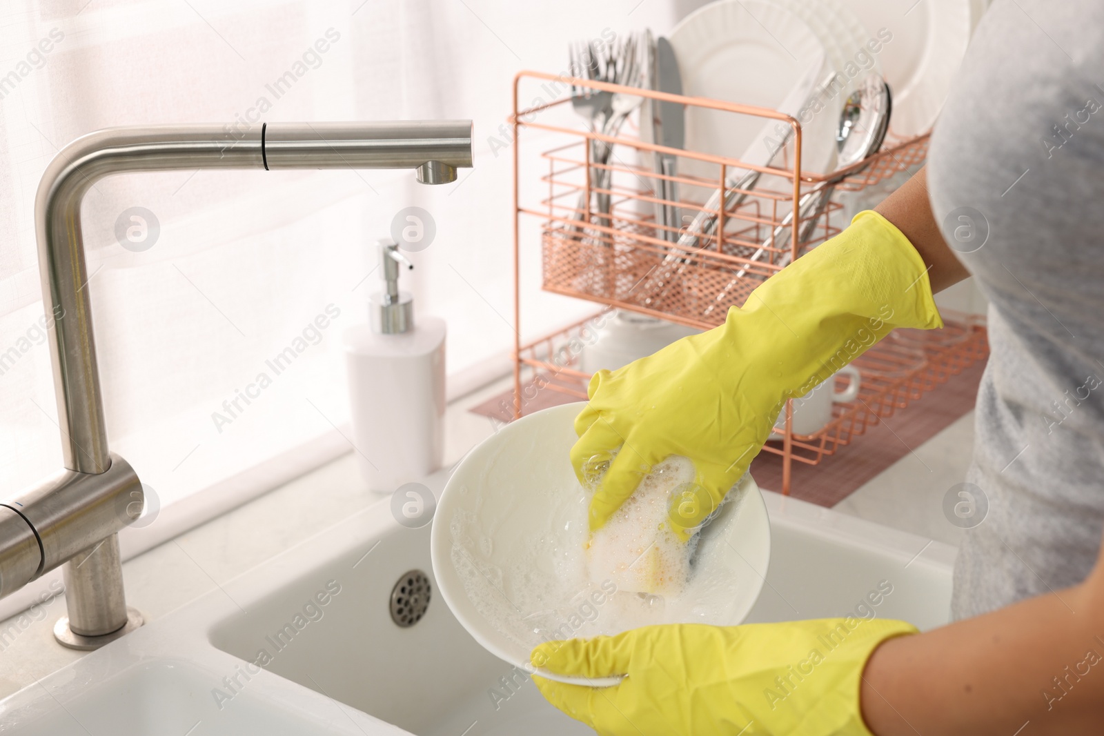 Photo of Woman washing bowl at sink in kitchen, closeup