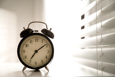 Photo of Alarm clock on windowsill, space for text. Morning time