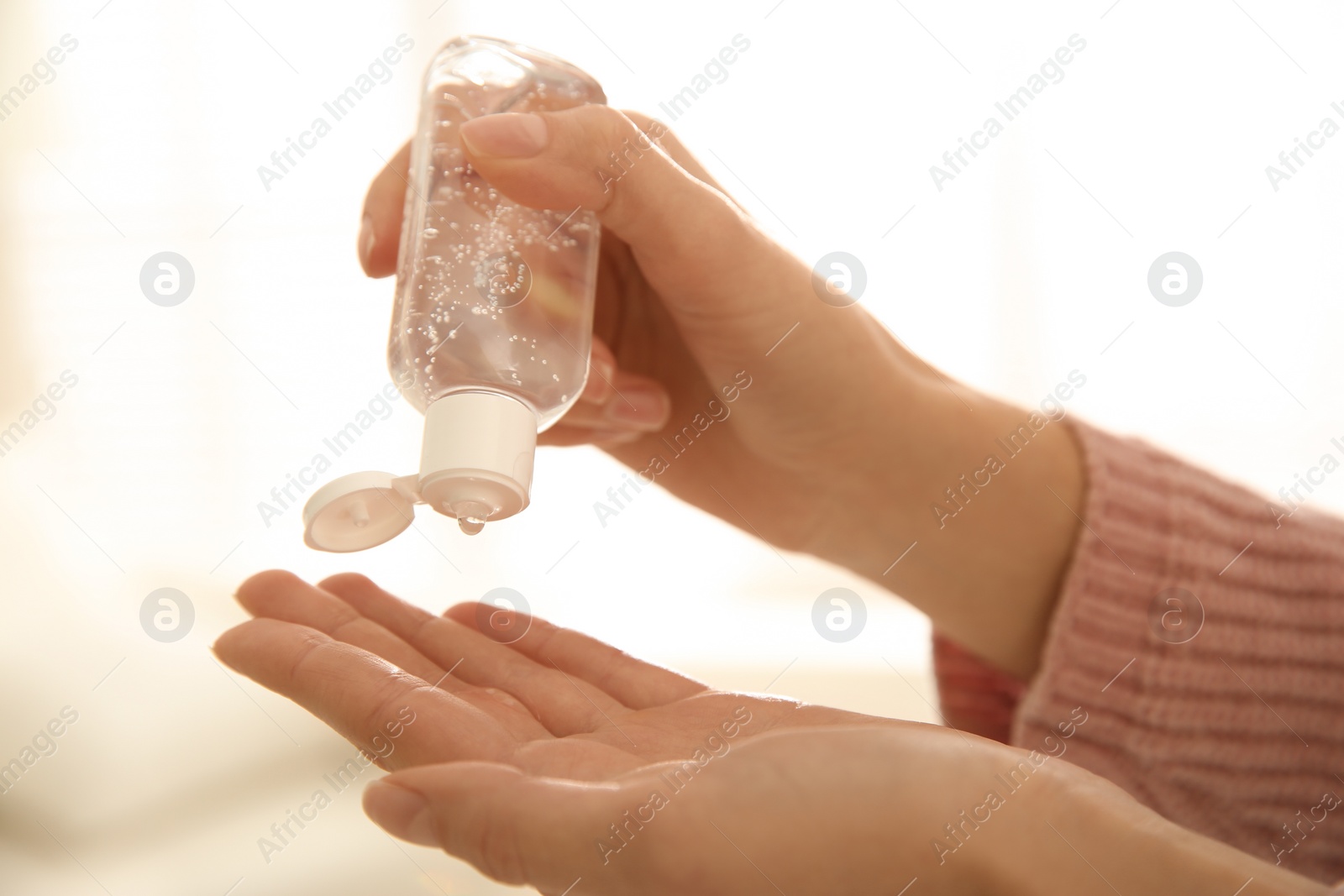 Photo of Woman applying antiseptic gel on blurred background, closeup