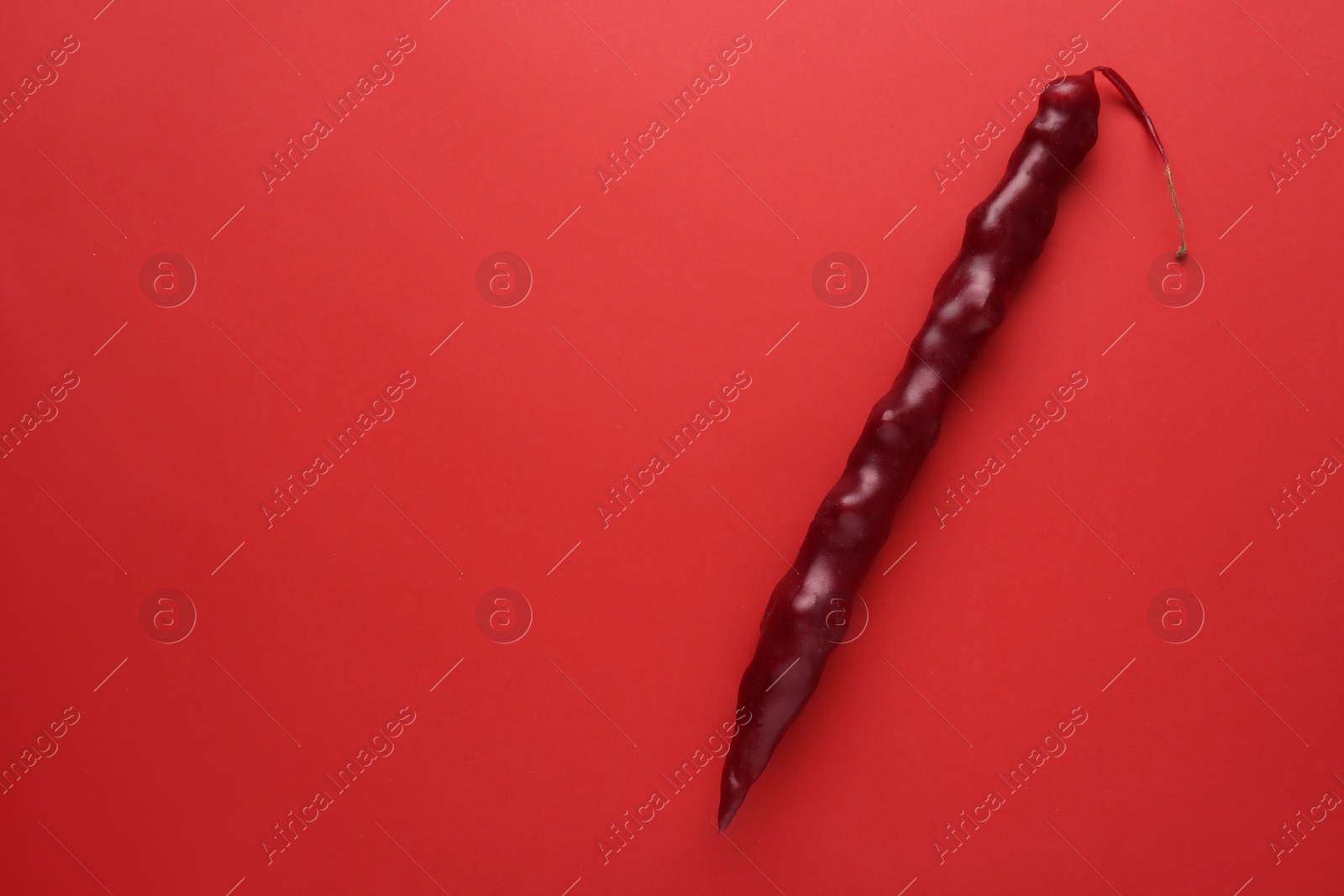 Photo of Delicious churchkhela on red background, top view. Space for text