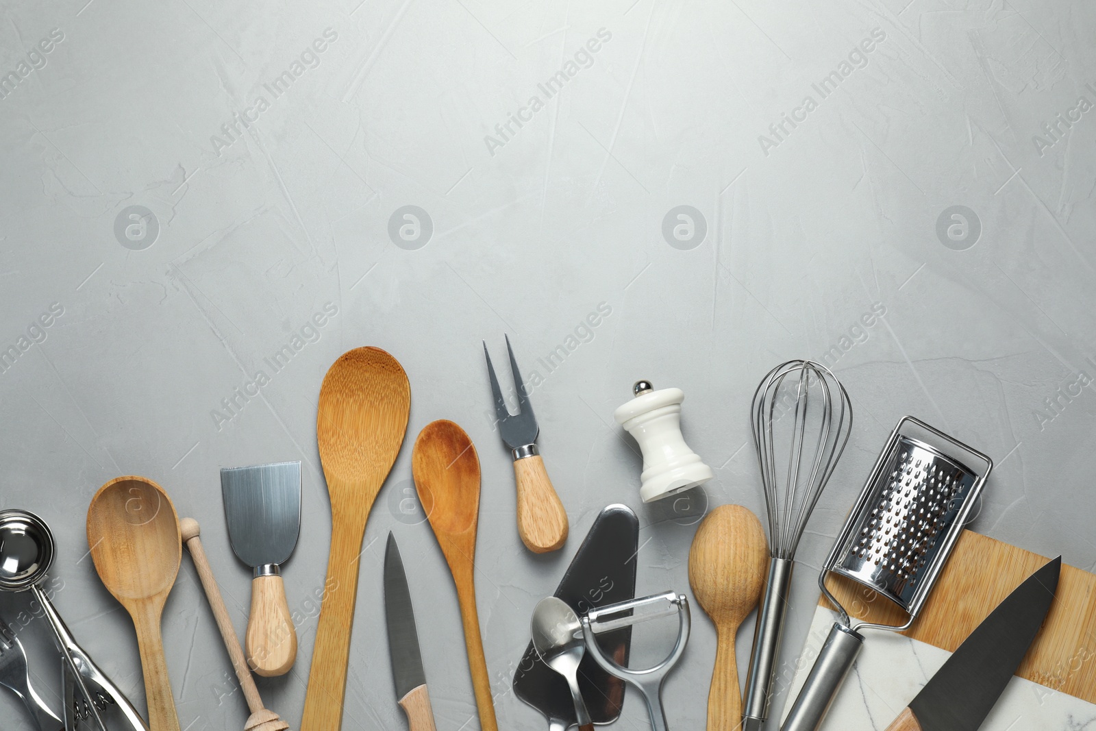 Photo of Set of kitchen utensils on light grey table, flat lay. Space for text