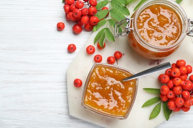 Flat lay composition with delicious rowan jam on white wooden table. Space for text