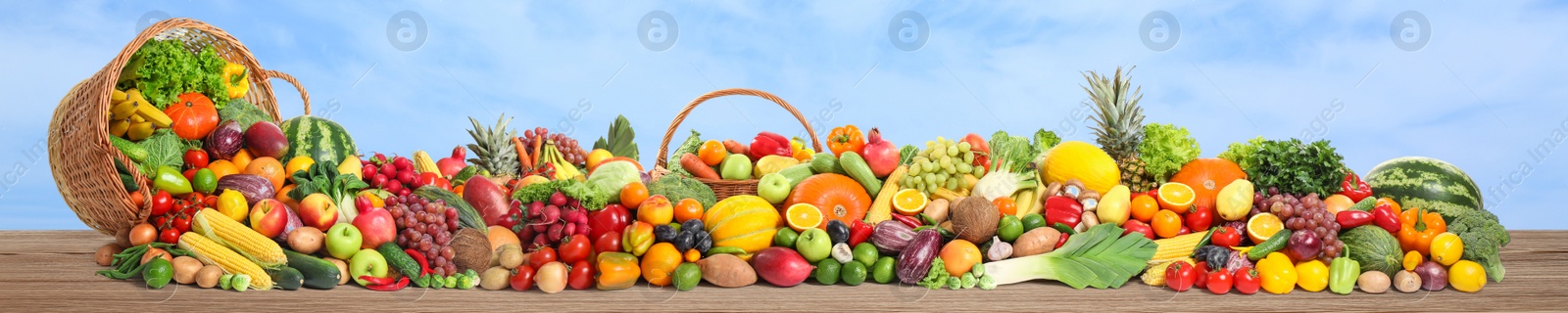 Image of Assortment of fresh organic fruits and vegetables on wooden table outdoors. Banner design