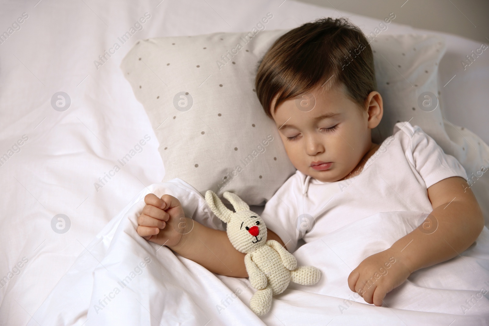 Photo of Cute little baby sleeping with toy at home. Bedtime