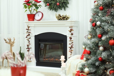 Photo of Beautiful living room interior with burning fireplace and Christmas decor