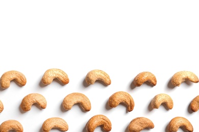 Photo of Tasty roasted cashew nuts on white background, top view. Space for text