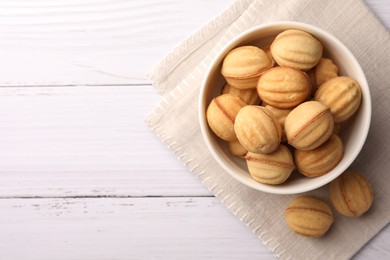 Photo of Delicious nut shaped cookies with boiled condensed milk on white wooden table, flat lay. Space for text