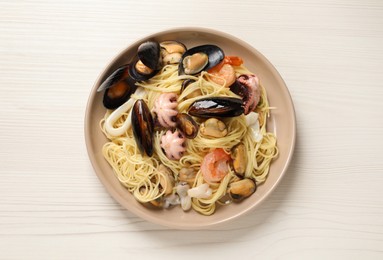 Delicious pasta with sea food on white wooden table, top view