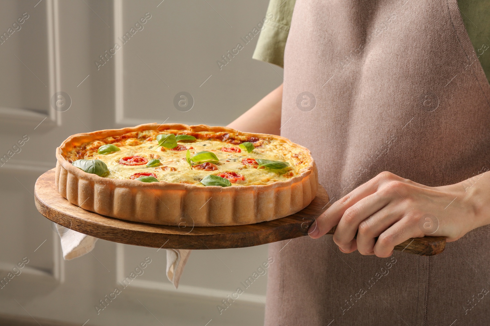 Photo of Woman with delicious homemade cheese quiche indoors, closeup