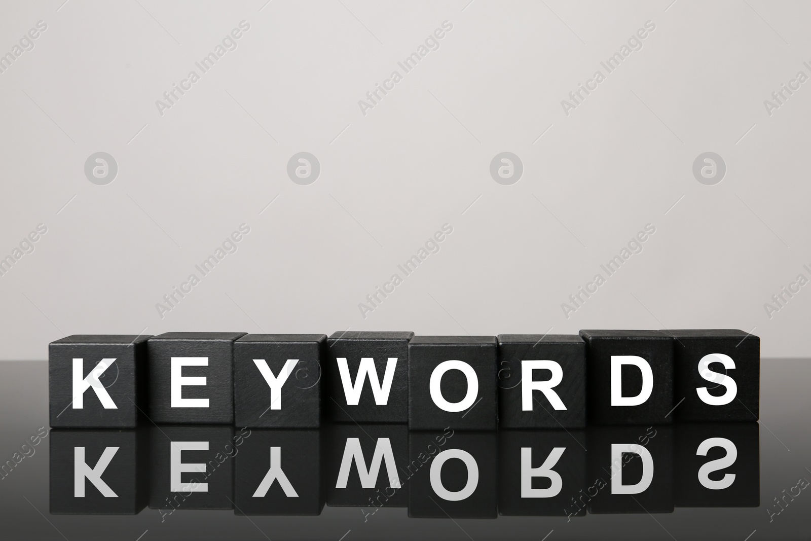 Photo of Black cubes with word KEYWORDS on light grey background