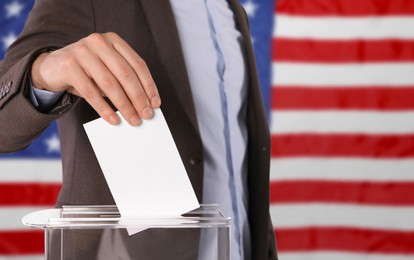 Election in USA. Man putting his vote into ballot box against national flag of United States, closeup. Banner design