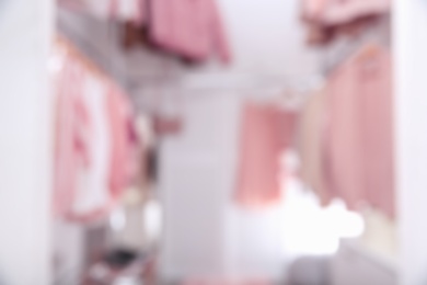 Blurred view of modern dressing room with different stylish clothes and accessories