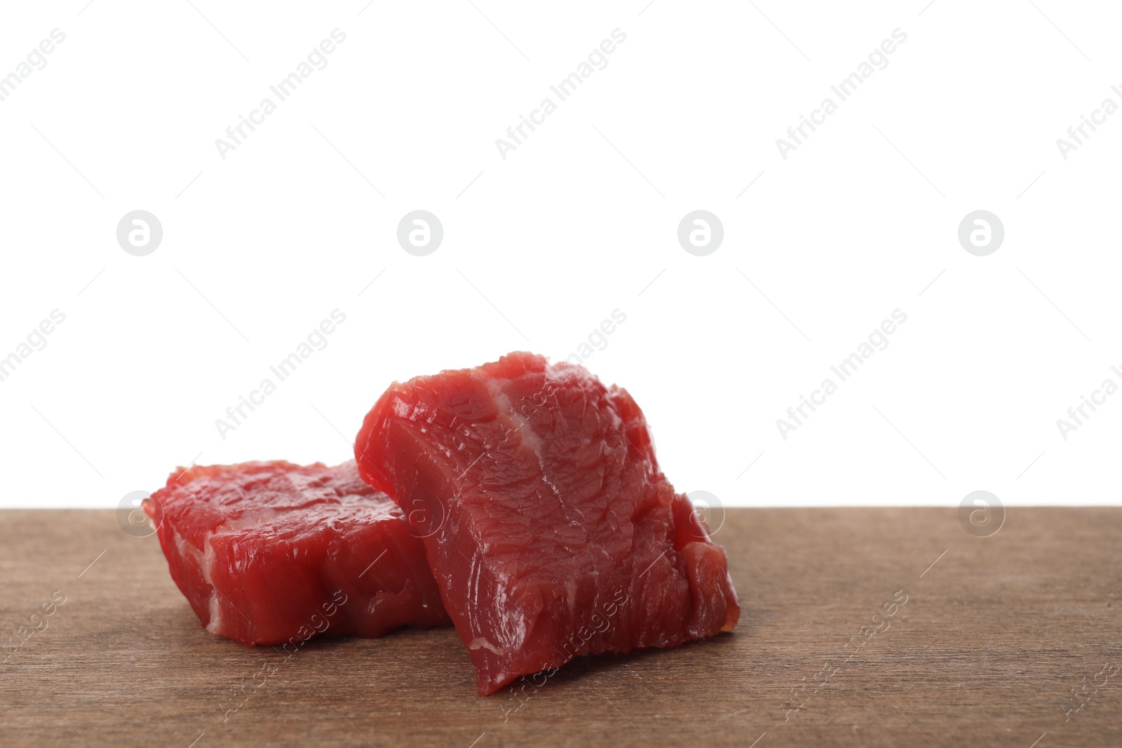 Photo of Pieces of raw cultured meat on wooden table against white background, space for text