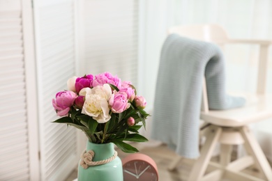 Photo of Vase with bouquet of beautiful peonies in room. Space for text