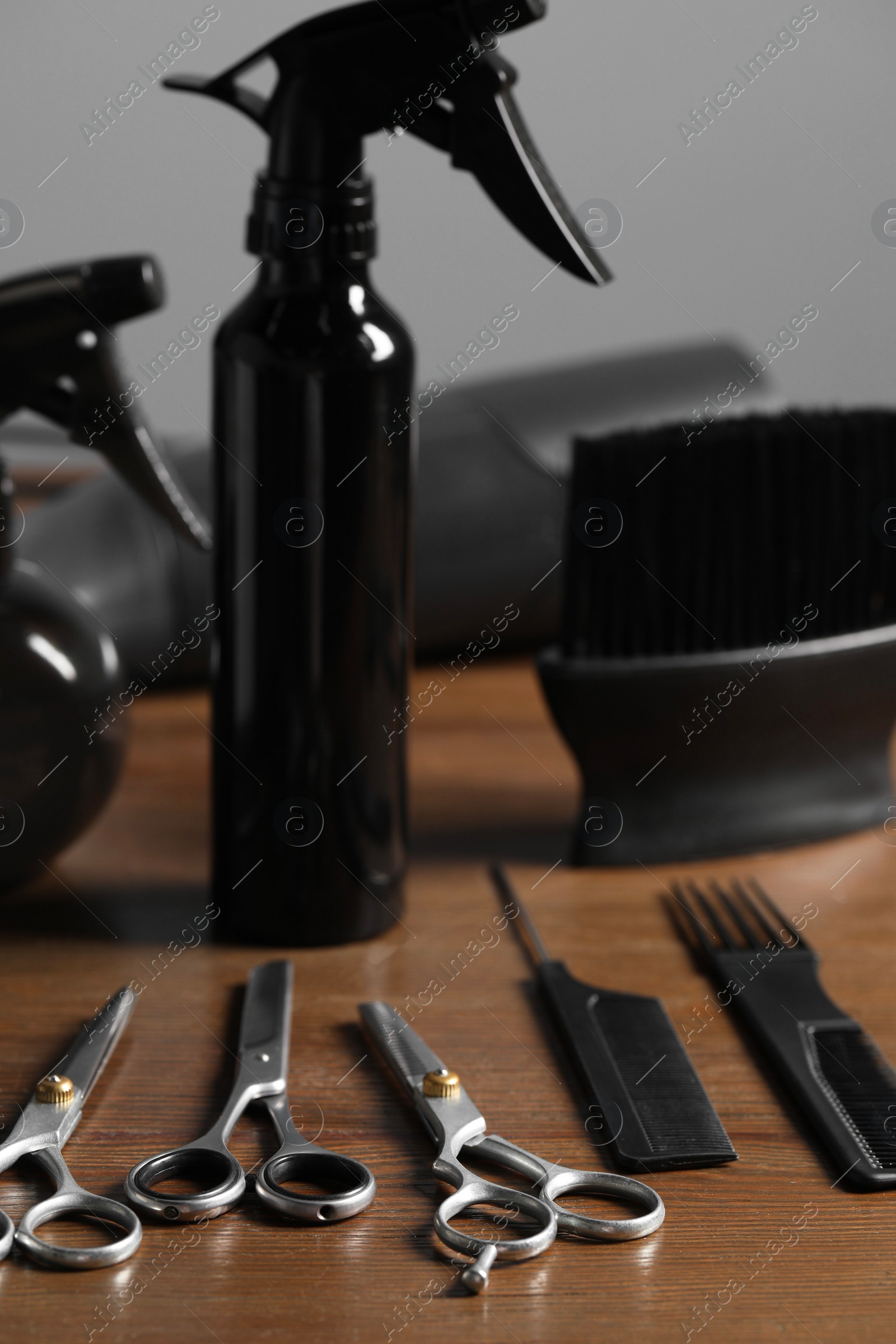 Photo of Hairdresser tools. Different scissors and combs on wooden table in salon, closeup