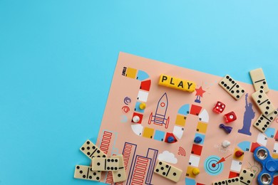 Photo of Components of board games on light blue background, flat lay. Space for text