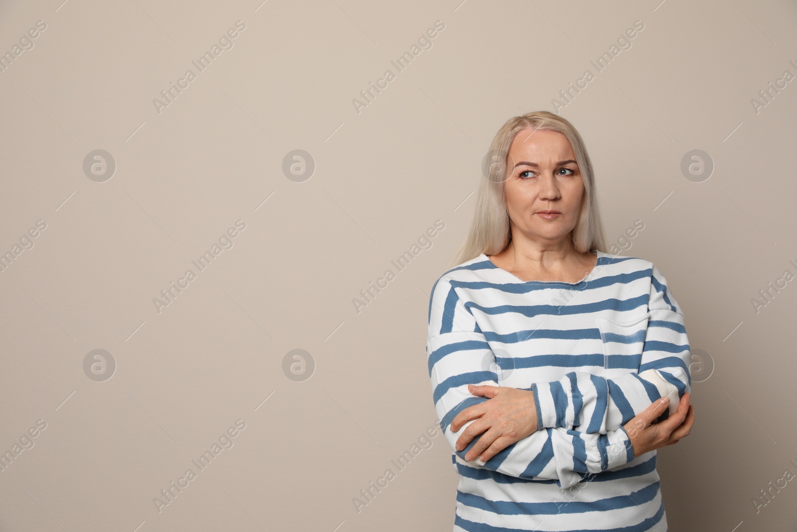 Photo of Emotional mature woman on beige background. Space for text