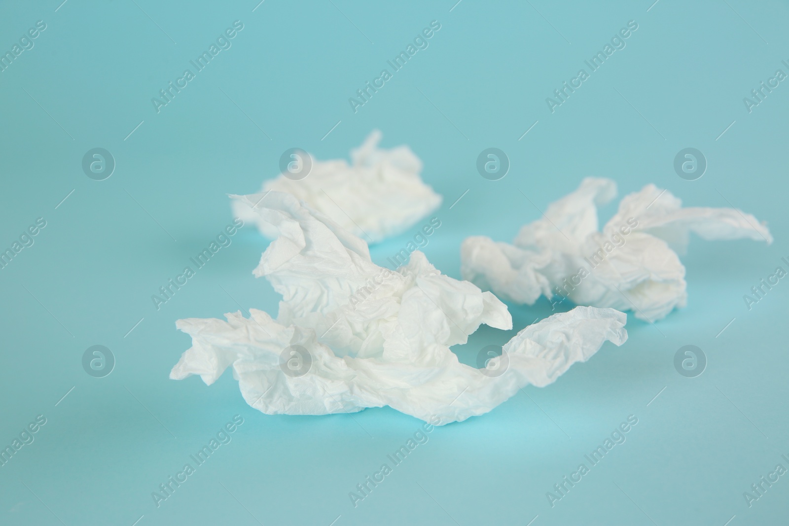 Photo of Used paper tissues on light blue background