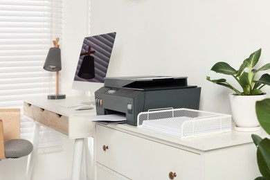 Photo of Stylish workplace with modern computer, printer and lamp