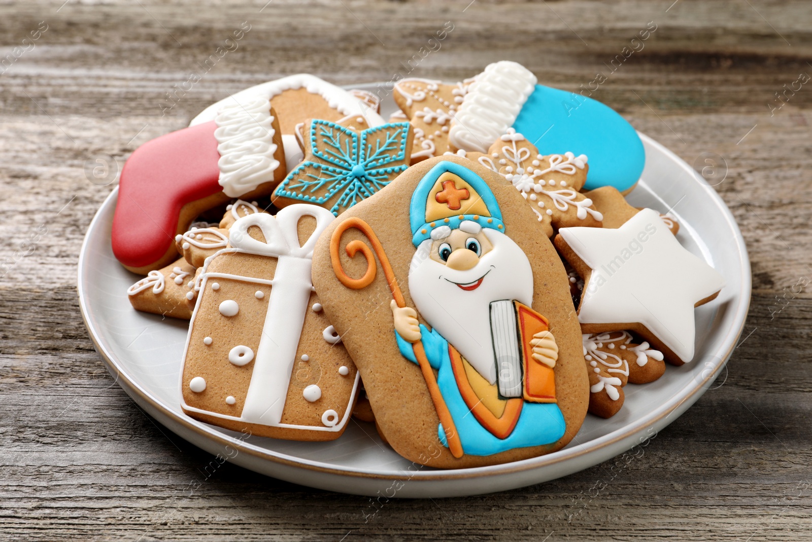 Photo of Tasty gingerbread cookies on wooden table, closeup. St. Nicholas Day celebration